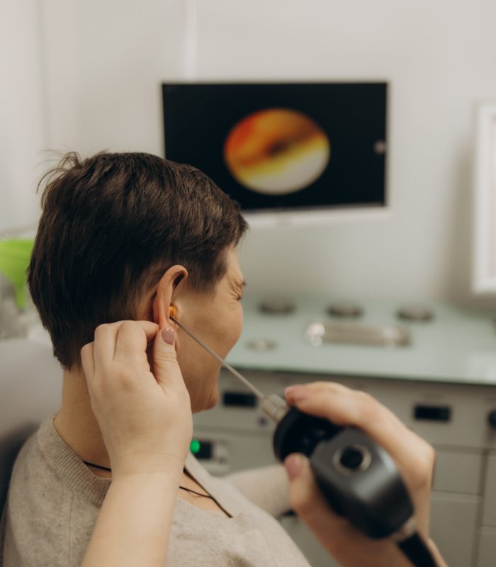 Hearing exam for elderly citizen people. Otolaryngologist doctor checking mature woman’s ear using otoscope or auriscope at medical clinic Hearing exam for elderly citizen people. Otolaryngologist doctor checking mature woman's ear using otoscope or auriscope at medical clinic