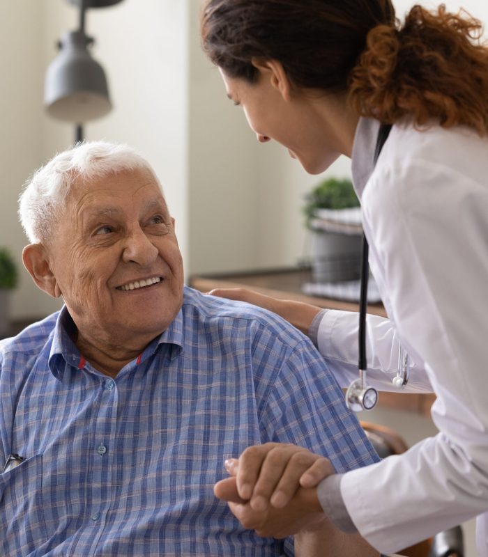 Close,Up,Caring,Nurse,Holding,Smiling,Mature,Patient,Hand,At